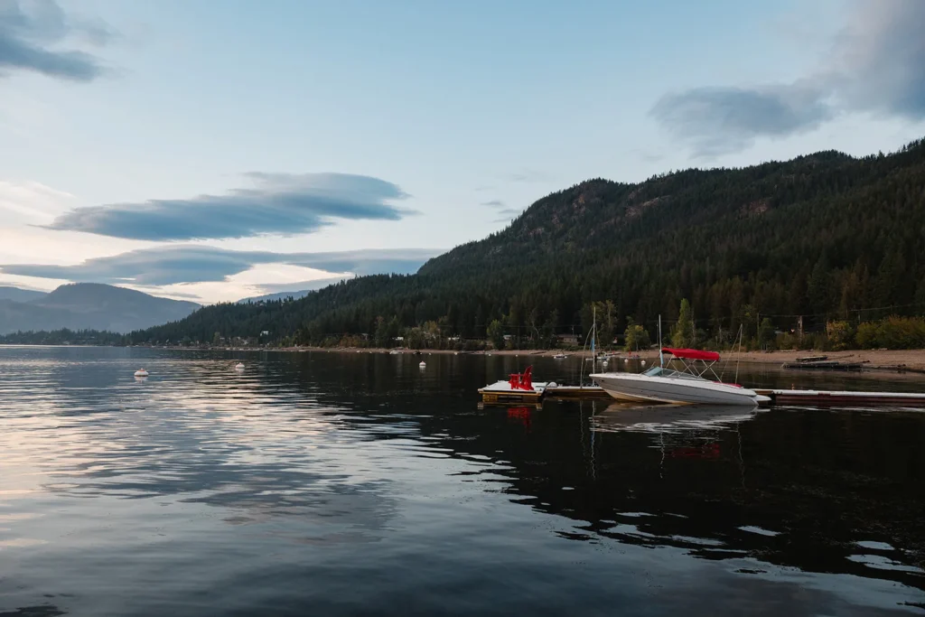 Lakeside dock with red chairs at dusk